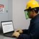 Electrical worker taking arc flash practice test on a laptop