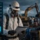 HAZWOPER-trained worker in full PPE reviewing site safety documentation at a hazardous waste remediation site