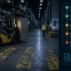 Forklift approaching a faded pedestrian crossing zone in a distribution warehouse — inspection failure scenario