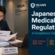 Regulatory affairs professional reviewing Japanese PMDA medical device dossier in a Tokyo office