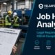 Safety manager reviewing a Job Hazard Analysis form on a clipboard at an industrial worksite